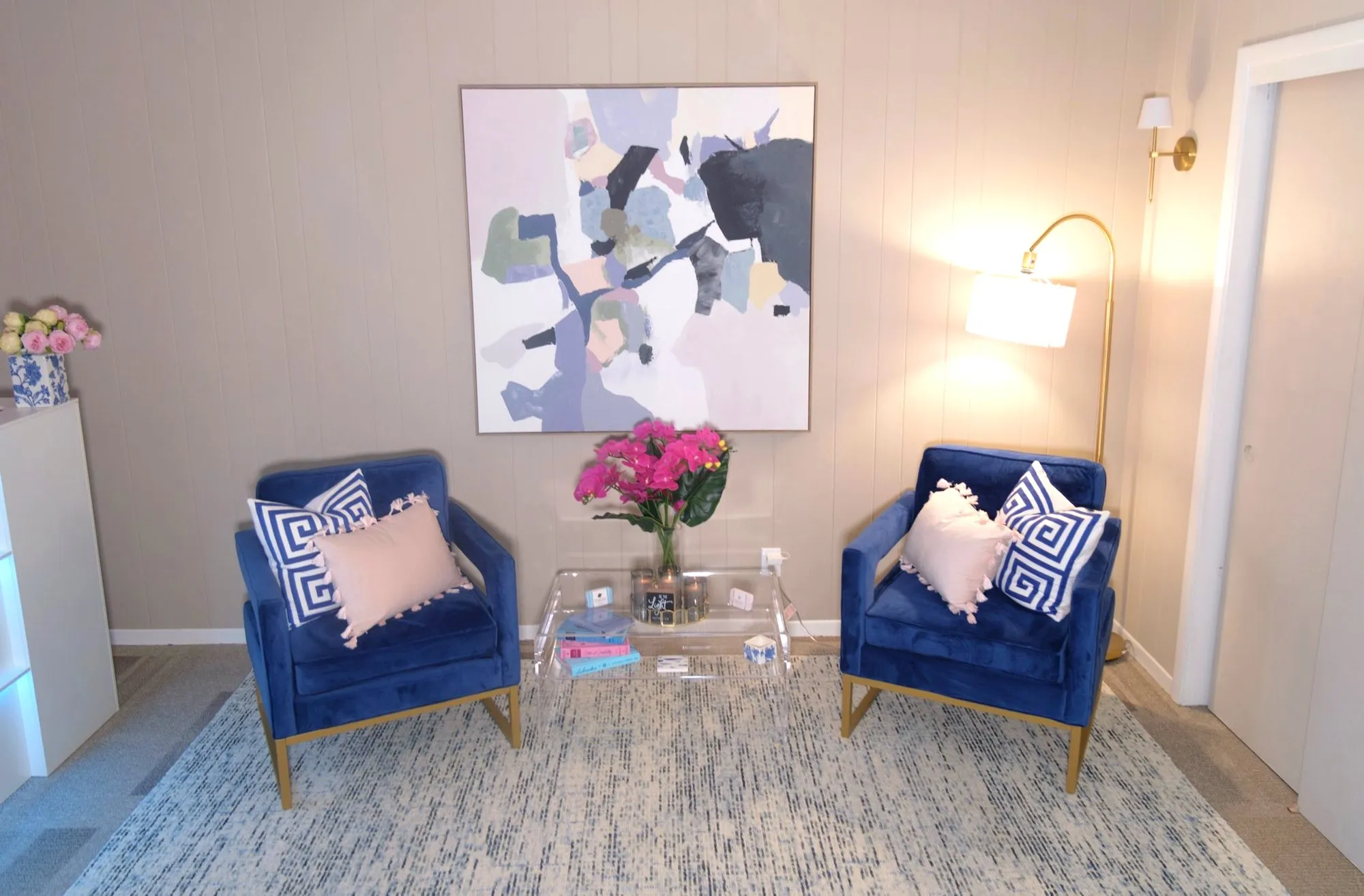 The consultation seating area at Felina Sno Wellness — two velvet chairs beneath abstract art